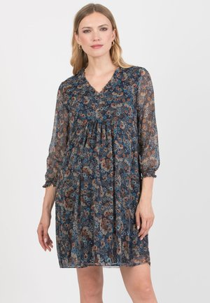 Blomsterkjole i mørkeblå, med lange gennemsigtige ærmer, en V-hals og en samlet talje. Delikate mønstre af blomster i orange og blå.