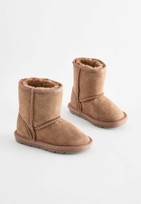 Tan mockasiner i mocka med en mjuk pälsfoder, med stickade detaljer och en platt gummisula, utformade för komfort och värme.
