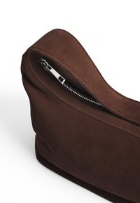 Brun mocka väska med en elegant design, försedd med dragkedjestängning. Texturen är mjuk, och formen är rundad med minimala sömnadsdetaljer.