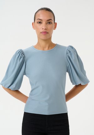 Light blue top featuring puffed short sleeves, a round neckline, and a fitted body. Made of soft, stretchy fabric with a smooth texture.