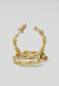 Gold twisted wire earrings featuring a smooth finish, with contrasting metal accents in copper and silver at the earring posts.