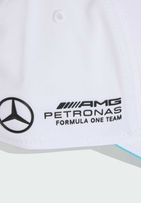 White baseball cap with black Mercedes logo and AMG Petronas Formula One Team text. Features a structured crown and contrasting turquoise accents.