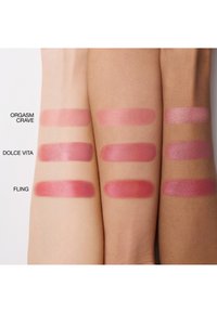 Trois bras avec des échantillons de blush dans trois teintes : "Orgasm Crave" (rose doux), "Dolce Vita" (rose) et "Fling" (rose plus profond), avec des textures lisses.