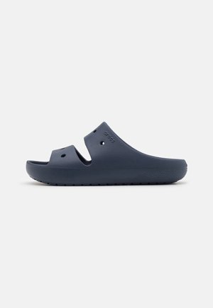 Sandale Crocs bleu marine à enfiler avec deux trous de ventilation, bout ouvert et semelle texturée sur fond blanc.