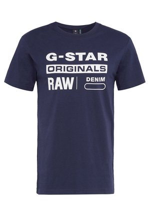 Navy blue cotton T-shirt featuring large white text: "G-STAR ORIGINALS RAW DENIM." Short sleeves and crew neckline, casual fit.
