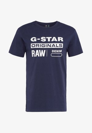 Mörkblå bomullst-skjorta med stor vit text: "G-STAR ORIGINALS RAW DENIM." Kortsleeves och rund halsringning, avslappnad passform.