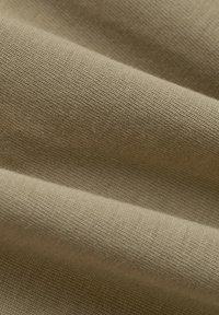Textilstoff in einem gedämpften Olivgrünton, mit einer glatten Textur, die eine enge Gewebestruktur und sichtbare Fasern aufweist.