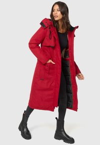 Longue parka rouge avec capuche, poches avant et doublure intérieure noire, dotée d'une fermeture éclair à l'avant et d'un bouton-pression.