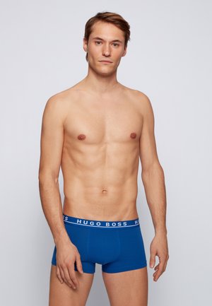 Men's blue boxer briefs featuring a branded white elastic waistband. Cotton blend material with a fitted design, smooth texture.