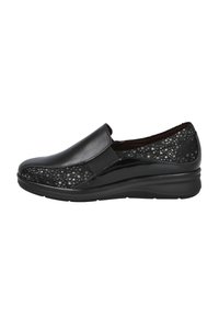 Zapato negro de tipo slip-on con una parte superior de cuero liso y paneles laterales texturizados con patrones. Cuenta con inserciones elásticas para mayor comodidad y una suela en cuña baja.