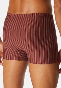 Bordeaux boxer shorts med vertikale striber i rød og hvid, med elastiisk talje og en blød, strækbar stoftekstur.