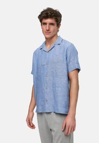 Lyseblå knapp-up skjorte laget av lin, med en avslappet passform, korte ermer og lysebrune knapper. Strukturert stoff med et uformelt design.