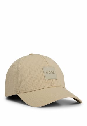 Beige strukturierte Baseballkappe mit gebogenem Schirm und quadratischem Patch mit dem "BOSS" Logo auf dem Frontpanel.