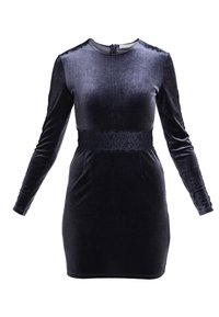 Svart sammetsklänning med långa ärmar, rund halsringning och en spetsdetalj vid midjan. Figursydd siluett, mjuk textur, med dragkedjestängning bak.