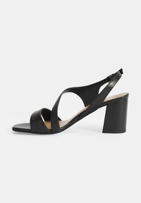 Zwarte leren sandalen met een blokhak, voorzien van kruislings gespen, een open teen en een verstelbare enkelband. Gladde textuur met een minimalistisch ontwerp.
