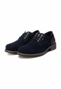 Zapatos de ante azul marino con puntera redondeada, diseño de cordones de dos ojales, detalles en cuero marrón y una suela texturizada.