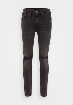 Jeans skinny negros con un acabado desgastado, que cuentan con dos desgastes en las rodillas, diseño clásico de cinco bolsillos y cierre de cremallera con botón.