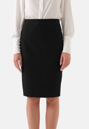 Zwarte kokerrok met een gladde textuur en een getailleerde silhoeet. Voorzien van decoratieve knopen aan de zijkant, gecombineerd met een witte blouse.
