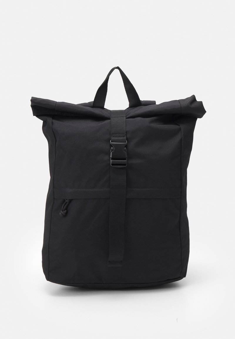 Mochila negra de tipo roll-top hecha de un tejido duradero. Cuenta con un cierre de hebilla en la parte frontal y un asa de transporte en la parte superior. Diseño minimalista sin patrones visibles.