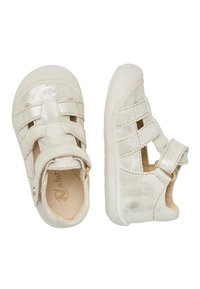 Srebrne metaliczne sandały dla małych dzieci z zamkniętym noskiem, regulowanym zapięciem i wyciętymi wzorami. Miękka podeszwa i teksturowana cholewka dla większej wygody.