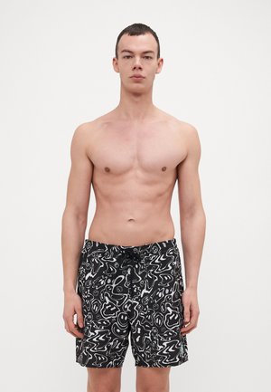Bañador negro con un patrón abstracto blanco, con cintura elástica y cordón. Fabricado en un material ligero y suave.