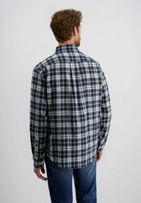 Heren geruit shirt in marineblauw, crème en groen; met knoopsluiting, lange mouwen en ronde onderrand; gemaakt van geweven stof; zichtbare stiksels.