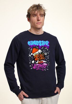 La felpa navy presenta un design grafico con un personaggio dei cartoni animati che tiene un boombox. Include il testo colorato "GANGSTER WRAPPER." Texture liscia.
