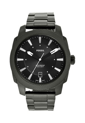 Black Fossil wristwatch with round textured bezel, silver hour markers, date display at 6, and linked metal strap showing 9:10:36 time.