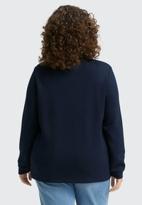 Marineblauwe sweatshirt met lange mouwen en een ronde hals, gemaakt van zachte stof. Heeft een relaxed fit met een gladde textuur en geen zichtbaar patroon.