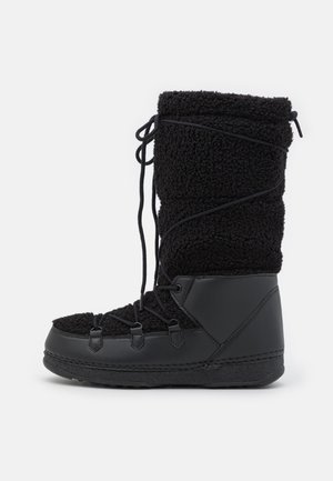 Botte d'hiver noire avec une tige texturée semblable à de la polaire, une tige haute, un laçage réglable et une semelle en caoutchouc pour plus de durabilité.