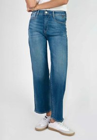 Jeans de denim de pierna recta en azul claro, con cierre de botón y cremallera, con bolsillos frontales y un acabado limpio y sin adornos.