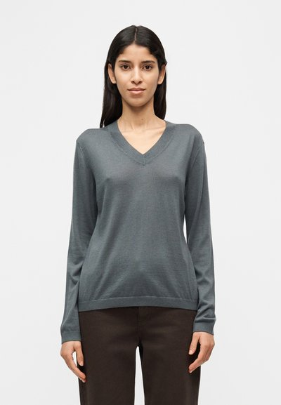 Pull gris à manches longues avec col en V, fabriqué en matière douce et légère. Présente une coupe décontractée et des accents côtelés subtils à l'ourlet et aux manches.