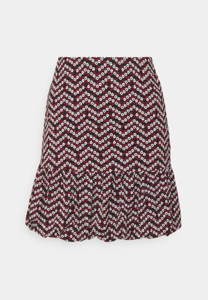 Jupe imprimée de fleurs rouges et blanches sur fond noir, avec un ourlet évasé et un motif en zigzag. Fabriquée en tissu à texture douce.