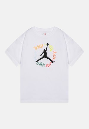 Bílý tričko s krátkým rukávem a černým logem Jumpman ve středu, obklopené barevným kruhovým textem s nápisem "Jordan."