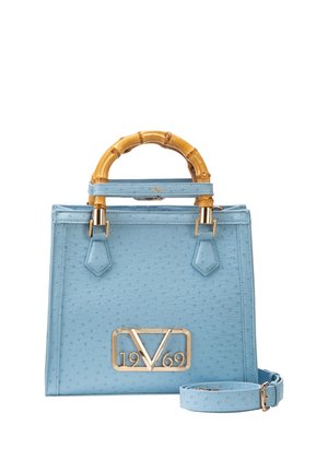 Lichtblauwe handtas met bamboe handvatten, gouden 1969-logo en bijpassende verstelbare schouderriem ernaast.