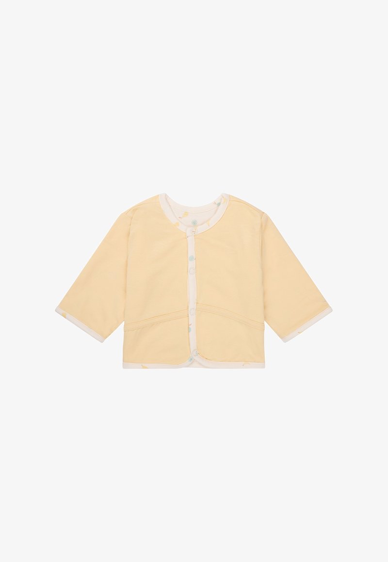 Cardigan en coton jaune avec des manches longues, un col rond et une fermeture à pression, doté d'une bordure à motifs à l'intérieur du col et des manches.