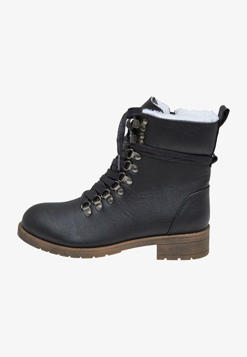 Crne kožne čizme do gležnja s okruglim vrhom, postavom od umjetnog krzna, metalnim rupicama i crnim vezicama. Masivna drvena peta, teksturirana gornja površina.