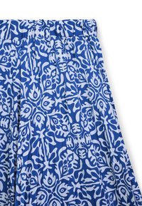 Tessuto blu e bianco con motivo floreale. Presenta delle pieghe e una vita elasticizzata, realizzato in materiale leggero.