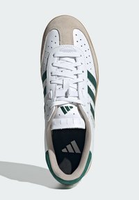 Weißer Sneaker mit grünen Streifen, Wildleder-Zehenkappe und perforierten Seiten. Verfügt über weiße Schnürsenkel und eine Gummisohle mit Markenlogo auf der Ferse.