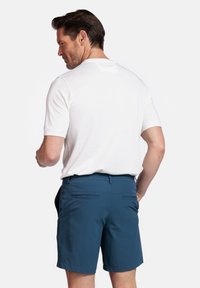 Witte shirt met korte mouwen, gecombineerd met blauwe shorts, met een gladde textuur, achterzakken en een ontspannen pasvorm.