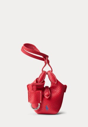 Kleine rode leren polstasje met een gestructureerd oppervlak, gestikte details, een gespband en een subtiel donker logo nabij de onderkant.