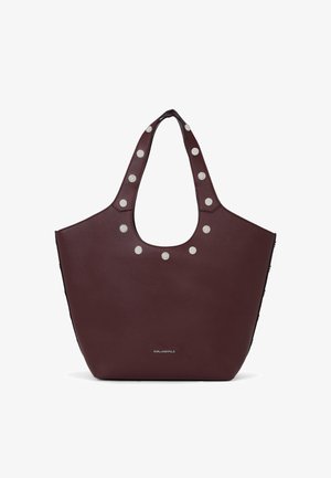 Dunkelbraune Ledertote-Bag mit breiten Griffen, verziert mit runden silbernen Nieten und kleinem Markennamen-Text unten in der Mitte.
