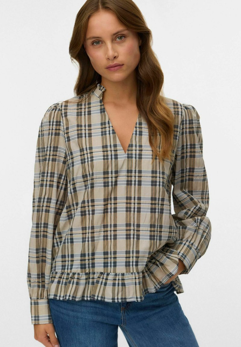 Camicia a quadri con scollatura a V, maniche lunghe, fondo beige e motivo a quadri blu e marrone. Presenta maniche arricciate e un orlo arricciato.