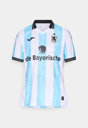 Světle modrý a bílý pruhovaný fotbalový dres s černým límcem a lemy na rukávech. Na přední straně se nachází emblém lva a logo "de Bayerische".