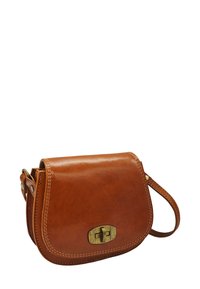 Sac bandoulière en cuir marron avec un rabat courbé, des accessoires en laiton et des coutures visibles sur les bords. Conception compacte avec une bandoulière.