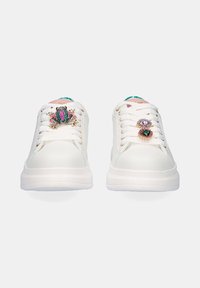 Zapatillas blancas con acentos decorativos, que presentan una rana metálica y gemas, punta redonda, cordones planos y suela texturizada.