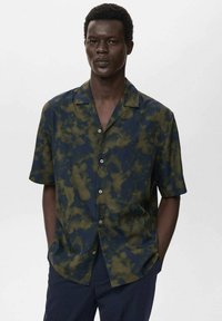 Korte mouwen overhemd in donkerblauw met een groen abstract patroon, gemaakt van lichtgewicht stof; beschikt over een knoopsluiting aan de voorkant en een camp collar.