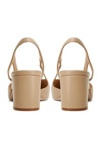 Sandali beige con tacco a blocco, finitura in pelle liscia, design con schiena aperta e cinturini sottili. Il tacco è alto circa 7,5 cm.
