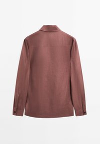 Langarmshirt in een stoffige rozenkleur, gemaakt van een gestructureerde stof. Bevat een kraag, geknoopte manchetten en een rechte zoom.