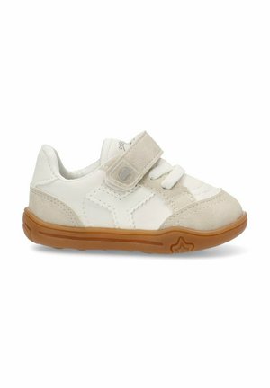 Zapatillas blancas con un acento de ante y una correa de Velcro. Presentan una suela de goma con un fondo marrón claro texturizado y detalles de costura.